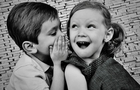 two children whispering to each other
